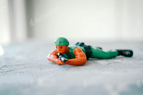 Preview: A toy soldier in camouflage and a helmet with a rifle in his hands crawls. War, defense.