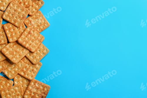 Preview: Delicious crackers on light blue background, flat lay. Space for text