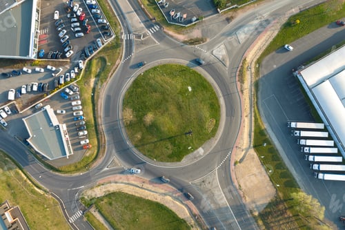 Preview: Aerial view of road roundabout intersection with moving heavy traffic.