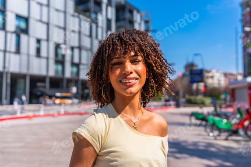 Preview: Young woman smiling in a city on a sunny summer day