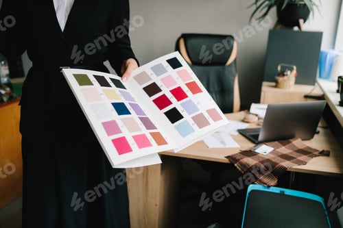 Preview: Designer compares textures and shades of fabric swatches for precise garment planning.