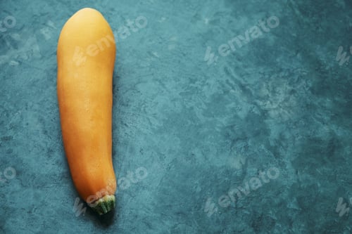 Preview: One yellow zucchini on kitchen table. Whole raw courgette