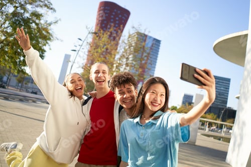 Preview: Happy boys and girls taking smiling selfie. Group of multiracial young people using smartphone