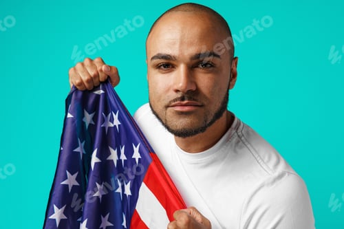 Preview: Portrait of young dark-skinned man proudly holding USA flag