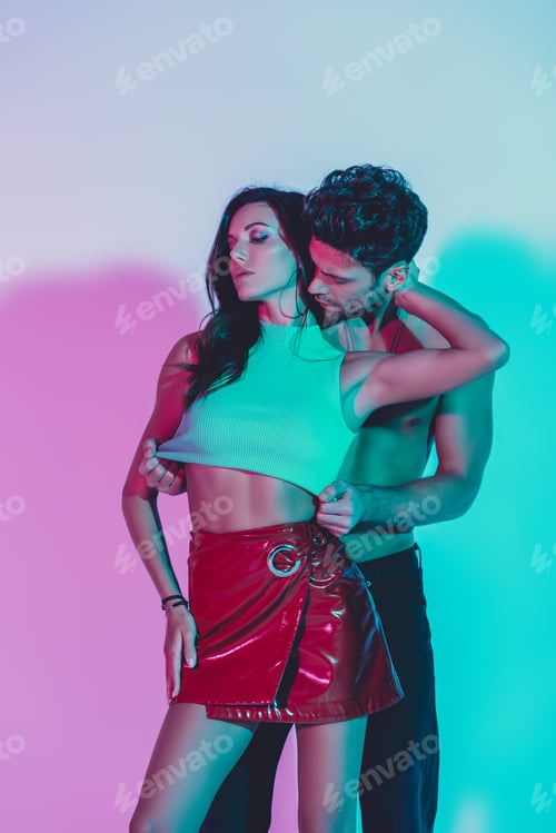 Preview: sexy man touching top of passionate girl embracing his neck on blue background with turquoise and