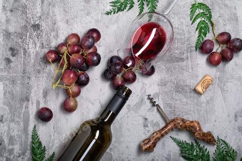 Preview: Flat lay composition with a bottle of wine, grapes and a glass on a concrete background.