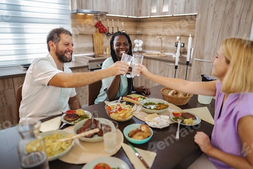 Preview: Joyful friends celebrating at a vibrant dinner gathering