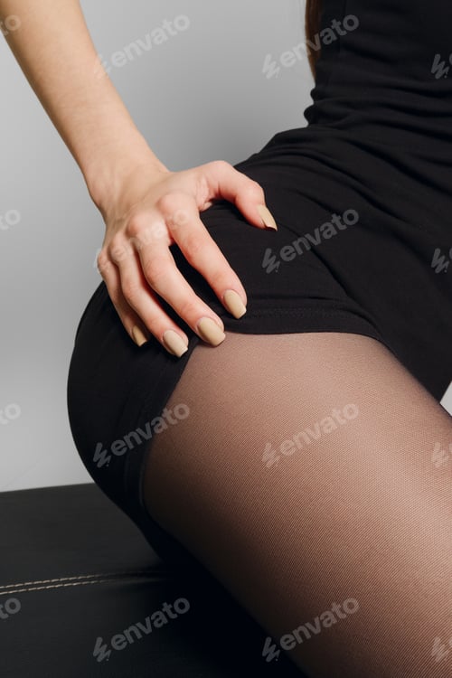 Preview: Female hand on hip in black pantyhose. Stripping short black dress.