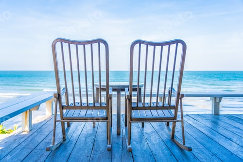 Preview: Empty wood chair and table at outdoor patio with beautiful tropi