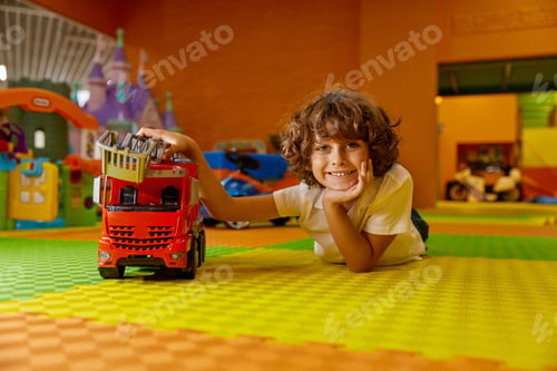 Preview: Boy child playing vehicle toys at kids care center
