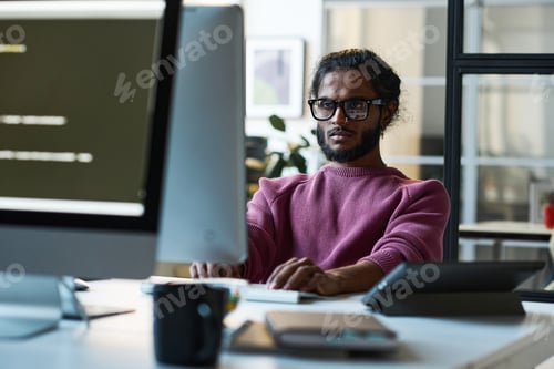 Preview: Young developer concentrating on his work on computer