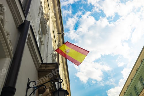 Preview: Spanish Flag Waving on a Building Under a Blue Sky with Clouds
