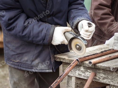 Preview: A man saws pipes with an angle grinder. Sparks fly in all directions