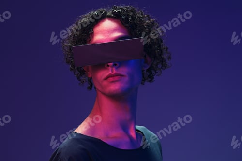 Preview: Interested stylish tanned curly man in black t-shirt trendy eyewear posing isolated on color pink