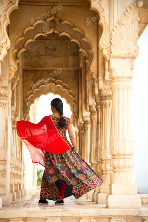 Preview: Young female tourist dancing between arches and Pillars.