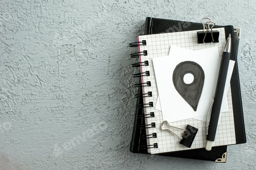 Preview: Top view of light bulb drawing on white sheet pen on spiral notebook and book on the left side on