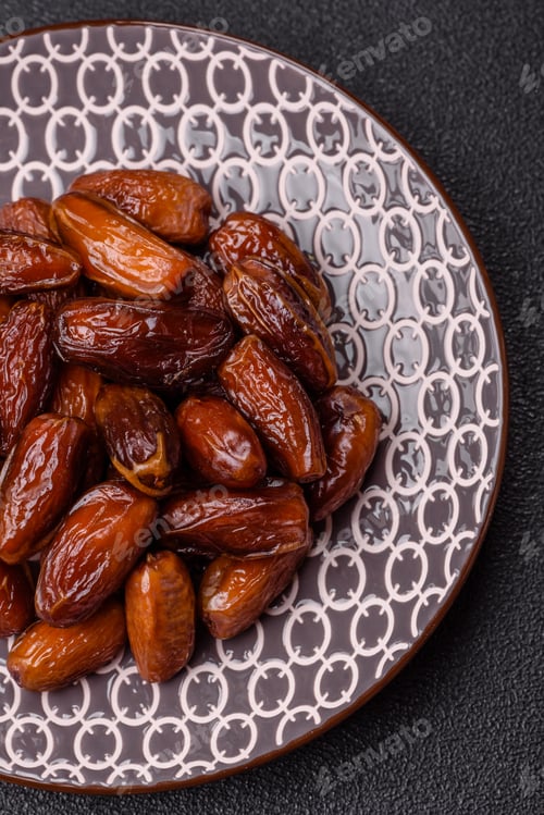 Preview: Dried dates on a ceramic plate for Ramadan or Iftar. Dates fruit as a background