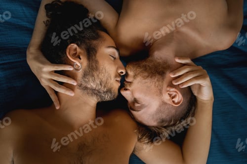 Preview: Gay couple lying on bed embracing together - homosexual couple hugging on night
