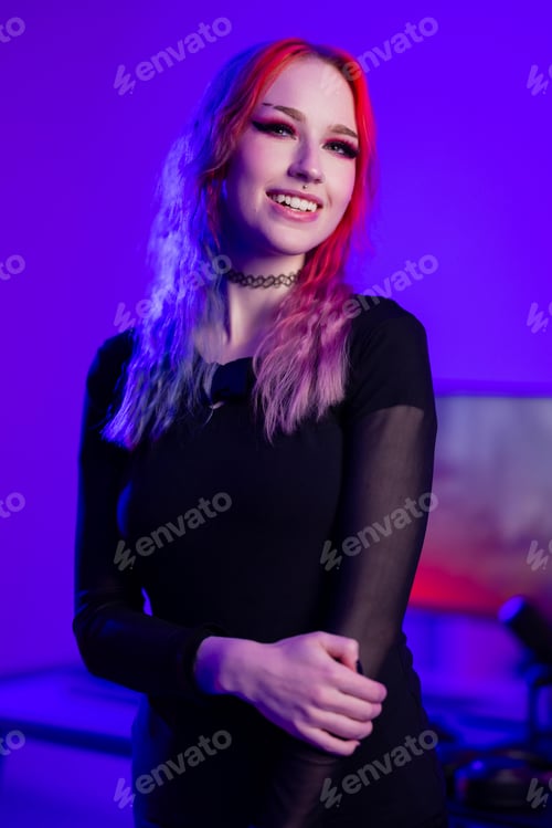 Preview: Young woman with vibrant hair in a purple-lit room, posing confidently