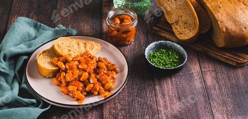 Preview: Baked beans with vegetables and rye bread on a plate on the table web banner