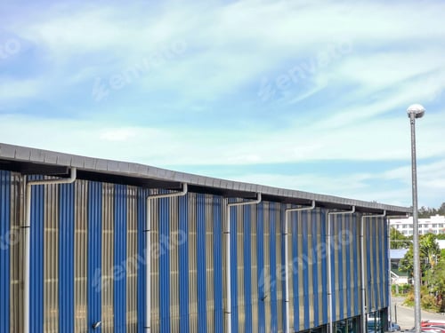 Preview: Warehouse or factory building against blue sky.