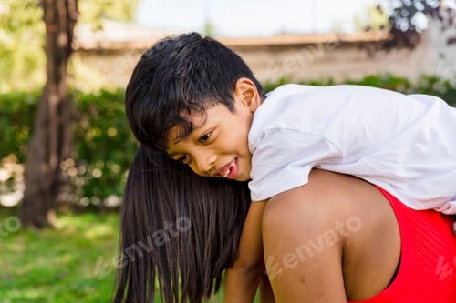 Preview: Happy mother and son enjoying together outdoors in a park.