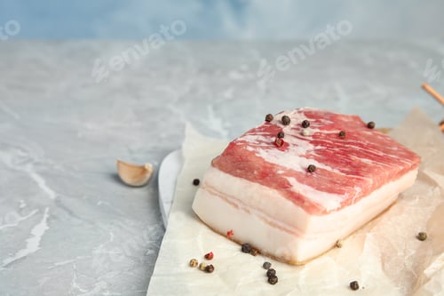 Preview: Pork fatback and pepper on grey stone table. Space for text