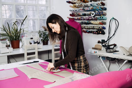 Preview: Female fashion designer tailor making sewing patterns at workplace in sewing studio