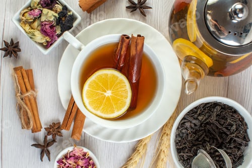 Preview: Close up view of tea break with cinnamon lime and lemon in a cup and pot around necessary