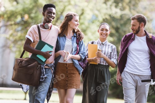 Preview: group of smiling multicultural students spending time together in park