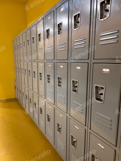 Preview: Rows of Gray School Lockers Lined up Against a Yellow Wall