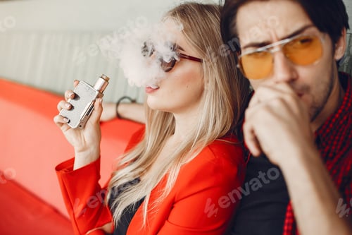 Preview: Stylish young couple with vape in a city