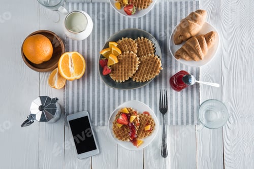 Preview: Top view of fresh tasty breakfast with waffles, coffee and smartphone with blank screen on table