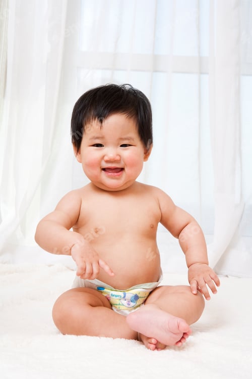 Preview: Adorable Infant Sitting and Smiling in a Nursery