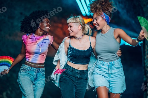 Preview: Friends walking and laughing together at music festival