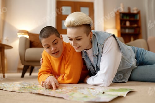 Preview: Young lgbt woman couple planning travel on weekends choosing rout on paper map