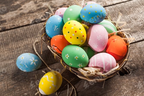 Preview: Easter eggs in nest on color wooden background