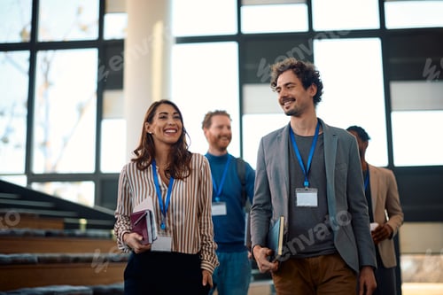 Preview: Happy business people walking out of a convention center after attending an education event.