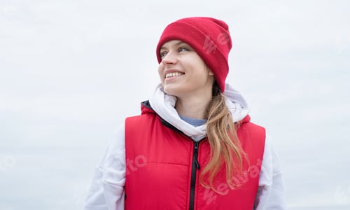Preview: Portrait of young woman in bright red and white sport clothes outdoors