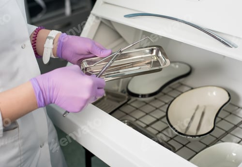 Preview: Dentist with gloved hands is working with dental equipment in dental office