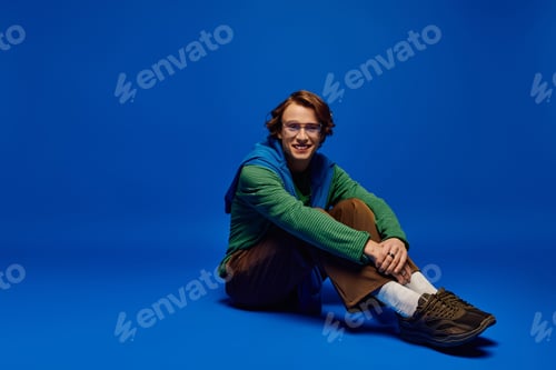 Preview: Young man shares his vibrant style with the world in a striking blue setting