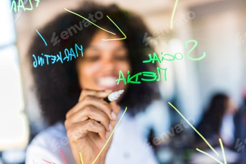 Preview: Businesswoman writing on glass wall