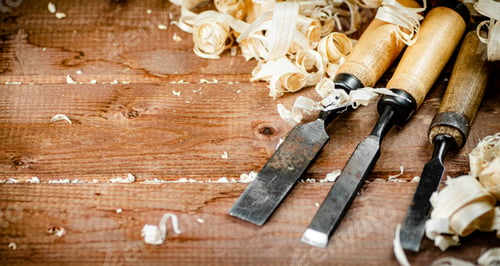 Preview: Chisels with wooden shavings. On a wooden background.