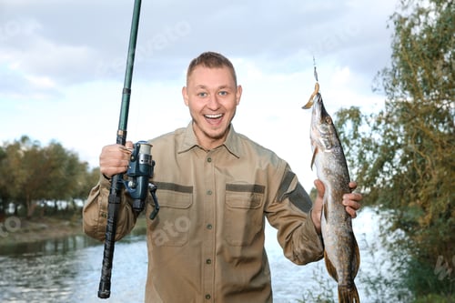 Preview: Man with rod and catch fishing at riverside. Recreational activity