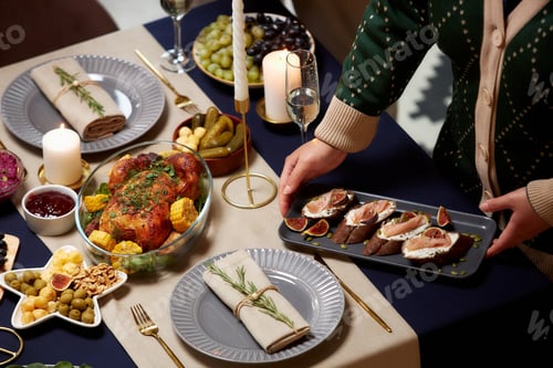 Preview: Female Hands Serving Plate with Meat Toasts on Table with Candles for Christmas Dinner