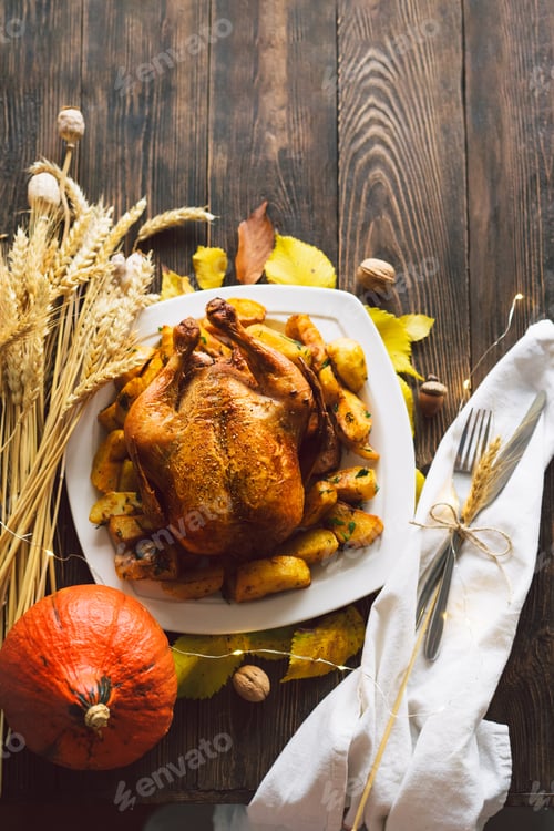 Preview: Autumn composition with leaves, ripe pumpkin and Thanksgiving turkey on a dark wooden table.