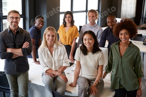 Preview: Portrait of a creative business team leaning on a desk, smiling to camera in office, elevated view