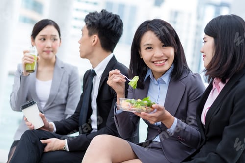 Preview: Business people having salad outside office