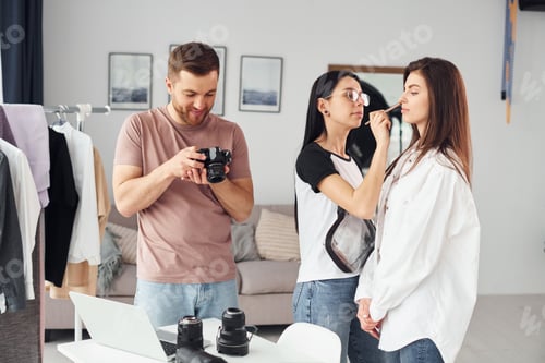 Vista previa: Preparando el modelo. Los fotógrafos trabajan en el interior de su estudio durante el día