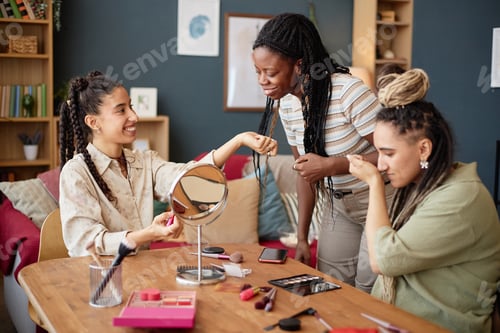 Preview: Multiethnic Young Women Testing Fragrances and Smiling Together Indoors